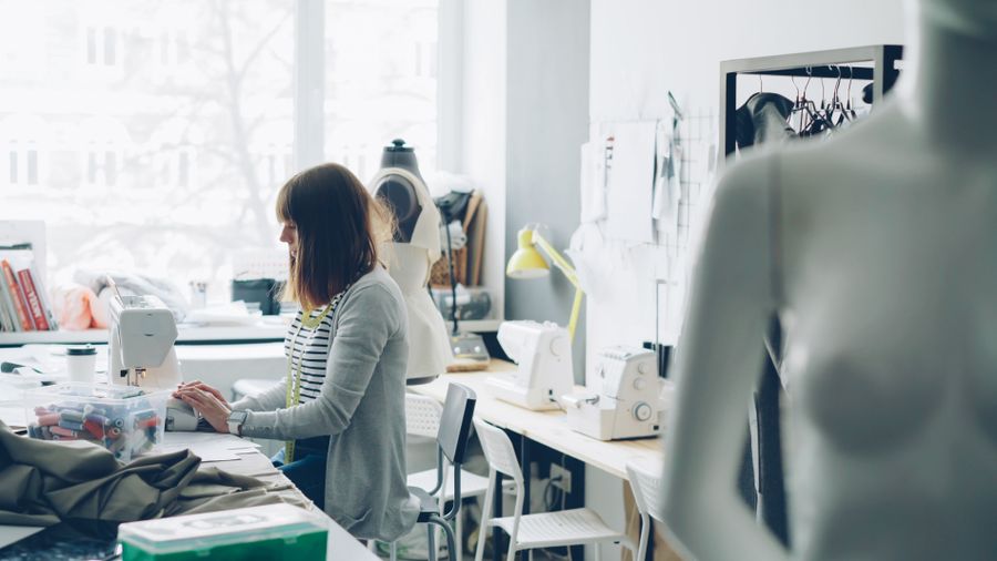 A pattern maker working at a bright studio desk