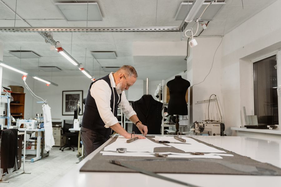 A pattern maker drafting at the studio table